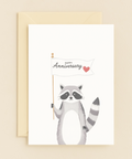 raccoon holding anniversary heart card